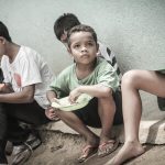 pmr_ashot_thumb_5 a group of boys eating. One boy looks up with sad face.