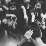pmr_ashot_thumb_8 a group of young boys point towards another boy who closes his ears with both hands.